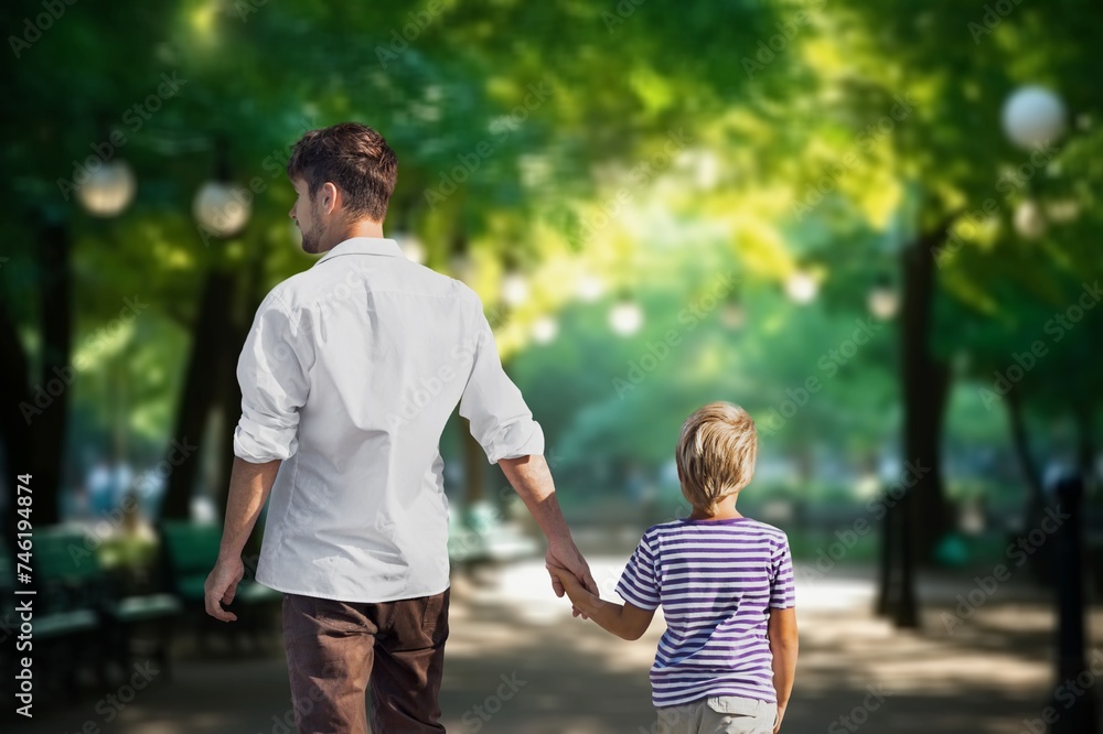 Fototapeta premium son schoolboy with father go through park