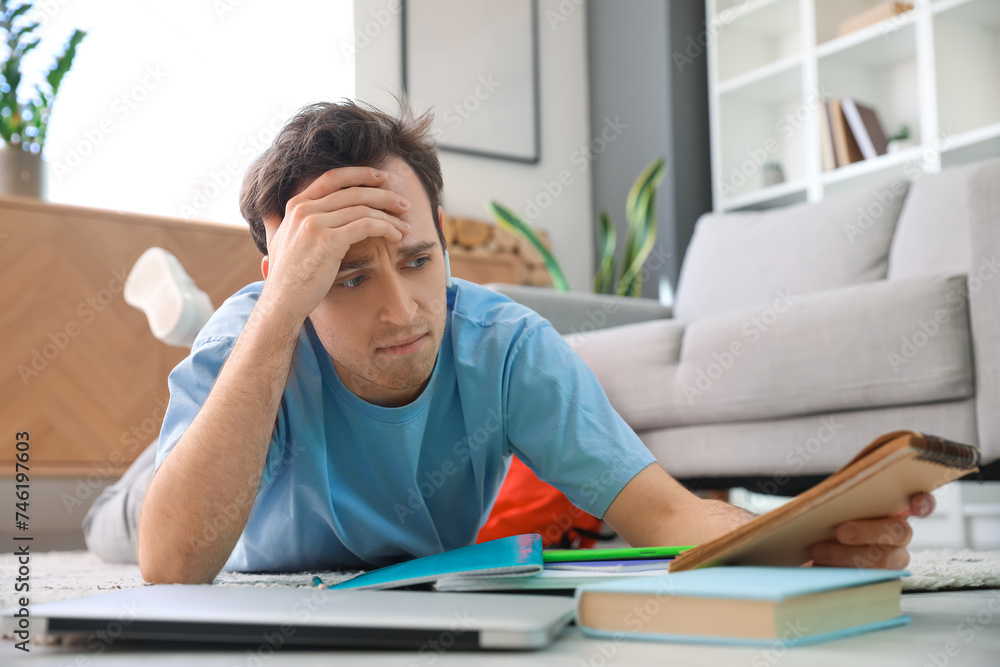 Displeased male student doing lessons at home Displeased male student doing lessons at home