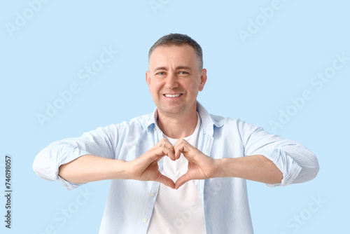 Mature man making heart wit...