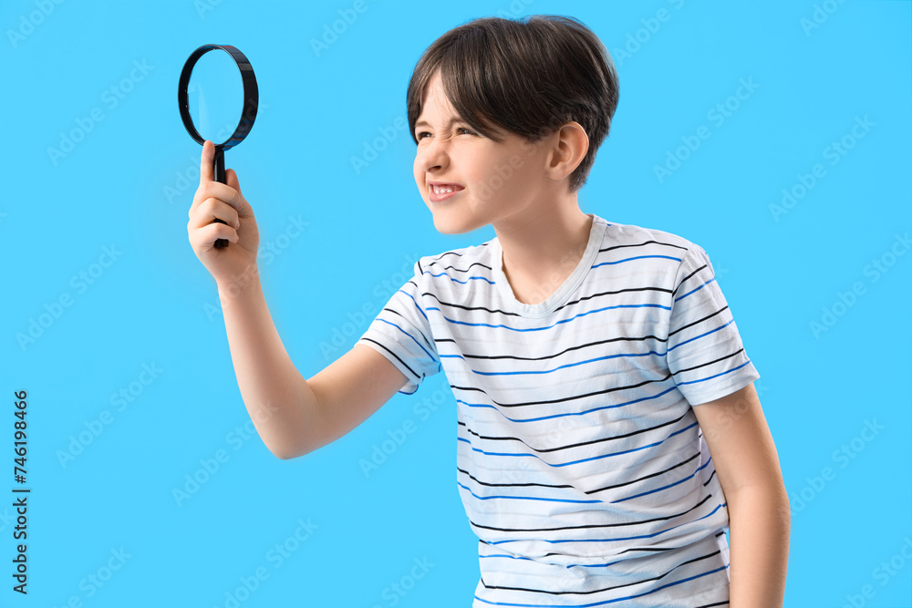 Little boy with magnifier on blue background Little boy with magnifier on blue background