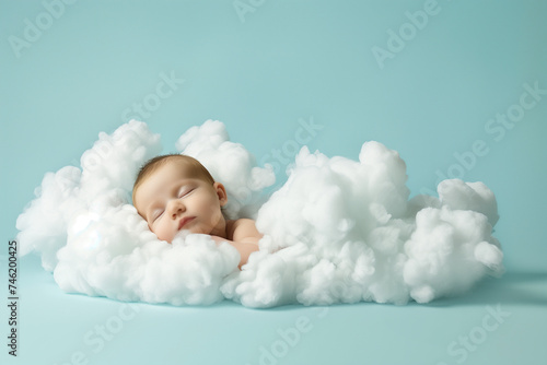 A precious sleeping baby boy wrapped in a fluffy white cloud blanket, floating gently on air in a light blue infinity studio background. Peaceful infant taking a nap while levitating photo