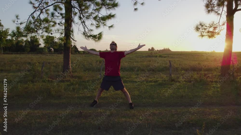Young man doing stretching exercises to relax and get fit in nature at sunset Young man doing stretching exercises to relax and get fit in nature at sunset