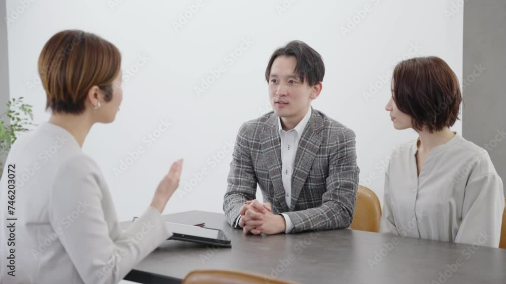 ブライダルプランナーと結婚式の打ち合わせをするカップル