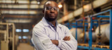 Confident industrial engineer with arms crossed in manufacturing plant