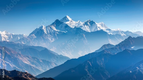 Panoramic view of a mountain range with snowy peaks under a clear blue sky.