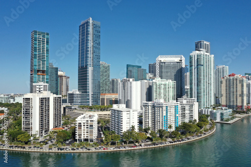 Aerial image of waterfront residential buildings in Brickell neighborhood of Miami, Florida reflected in calm water of Biscayne Bay on sunny morning. © Francisco