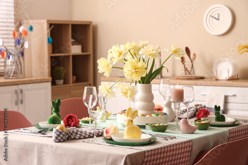 Wallpaper Mural Stylish table setting with vase of flowers, Easter bunnies, candle and painted eggs in kitchen Torontodigital.ca