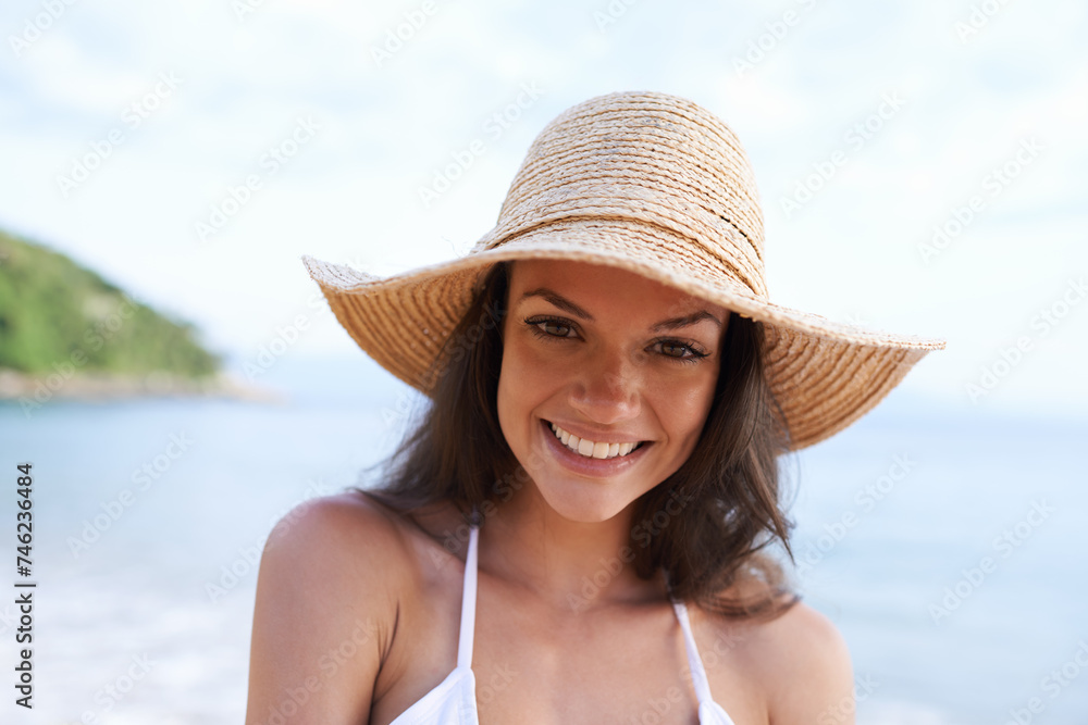 Beach, smile and portrait of woman for holiday, vacation and adventure for tropical travel. Happy, nature and female person with hat by ocean or sea water on outdoor summer weekend trip by island.