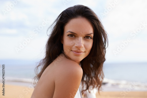 Beach, sea and portrait of woman on tropical vacation, adventure or holiday for travel. Happy, nature and young female person with positive attitude by ocean on summer weekend trip by island.