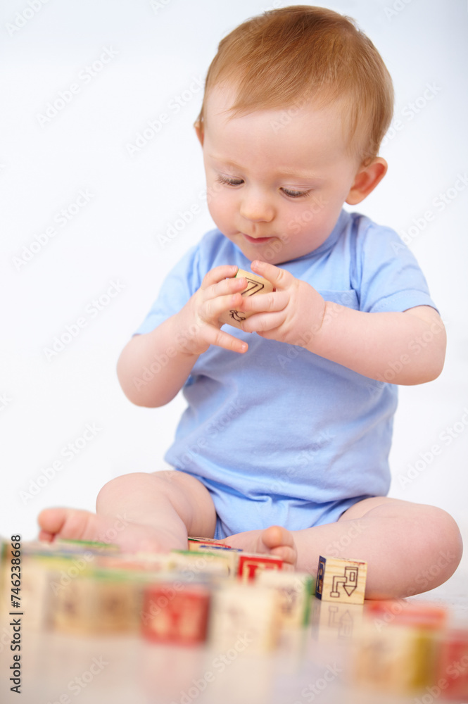 Boy, baby and playing with wooden blocks or toys for childhood development on a gray studio background. Little toddler, cute or adorable child learning shapes, letters or building on mockup space Boy, baby and playing with wooden blocks or toys for childhood development on a gray studio background. Little toddler, cute or adorable child learning shapes, letters or building on mockup space