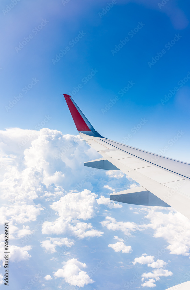 View from the airplane window at a beautiful cloudy sky and the airplane wing View from the airplane window at a beautiful cloudy sky and the airplane wing