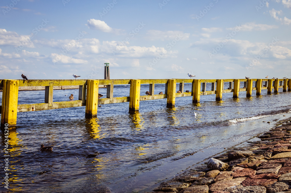 Yello fence in the sea water with lighhouse and blue sky on the background