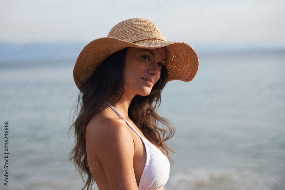 Smile, holiday and woman with hat at beach for travel adventure, thinking and relax in nature. Sunshine, summer and happy face of girl at ocean on vacation with water, reflection and resort in Bali.