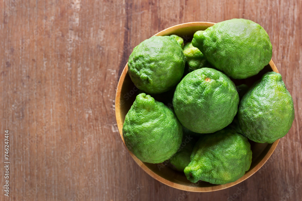 Bergamot, kaffir, fresh bergamot in wooden bowl on table, healthy, herb, herbal concept. Bergamot, kaffir, fresh bergamot in wooden bowl on table, healthy, herb, herbal concept.