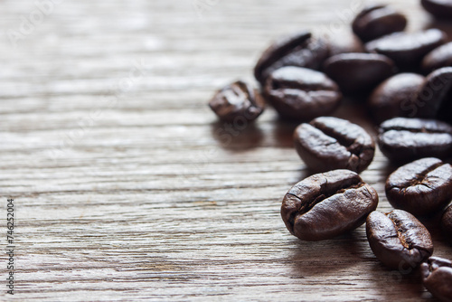 Coffee beans on grunge wooden background, close up, copy space.