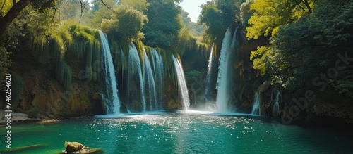 A large waterfall stands prominently in the center of a body of water, offering a breathtaking sight for visitors.