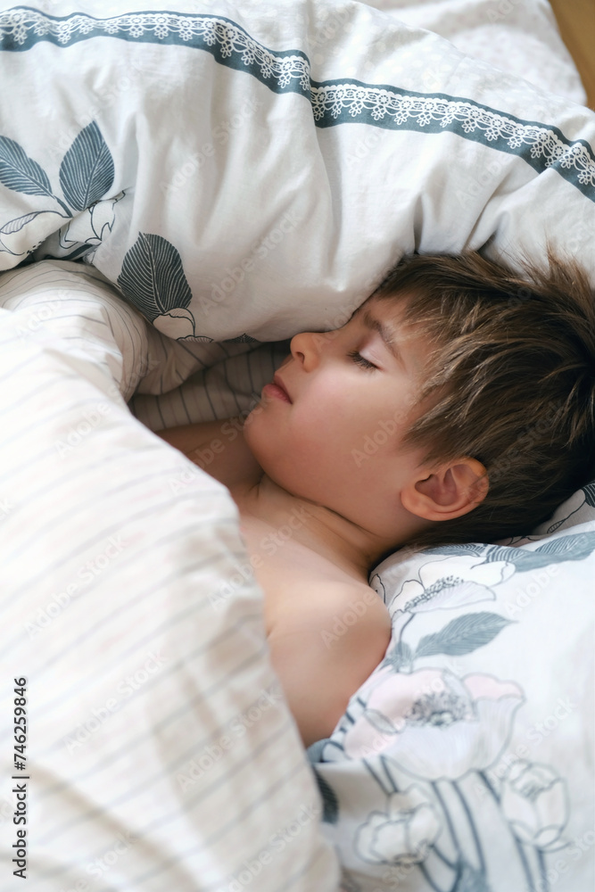 Cute little toddler boy is sleeping with beige plaid at home. Bedtime, napping Cute little toddler boy is sleeping with beige plaid at home. Bedtime, napping