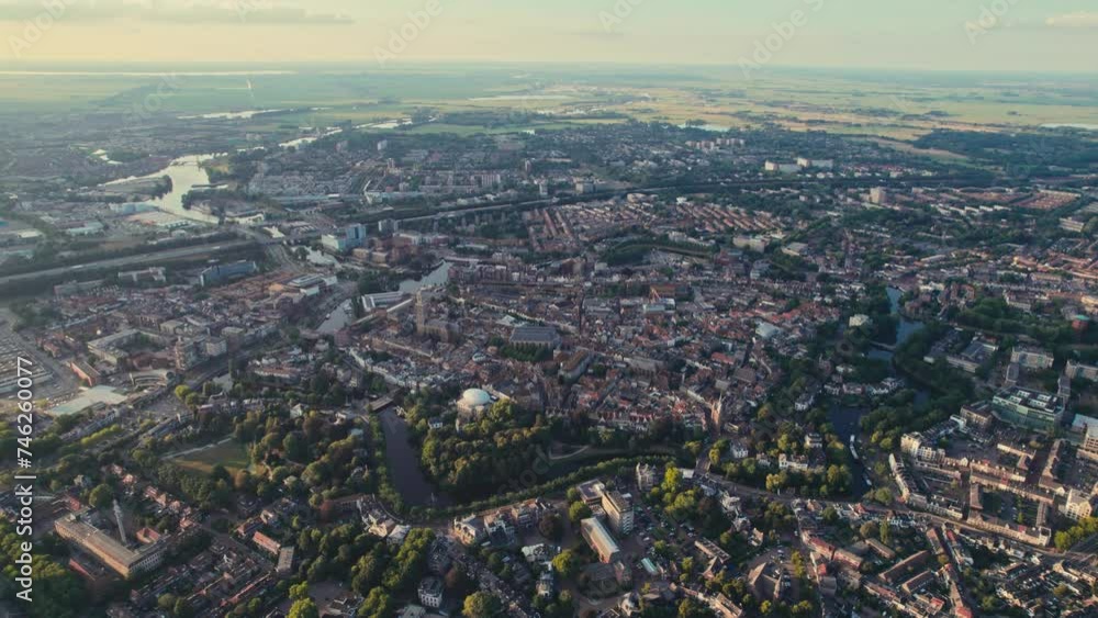 A sprawling cityscape during golden hour, with rivers and greenery, aerial view A sprawling cityscape during golden hour, with rivers and greenery, aerial view