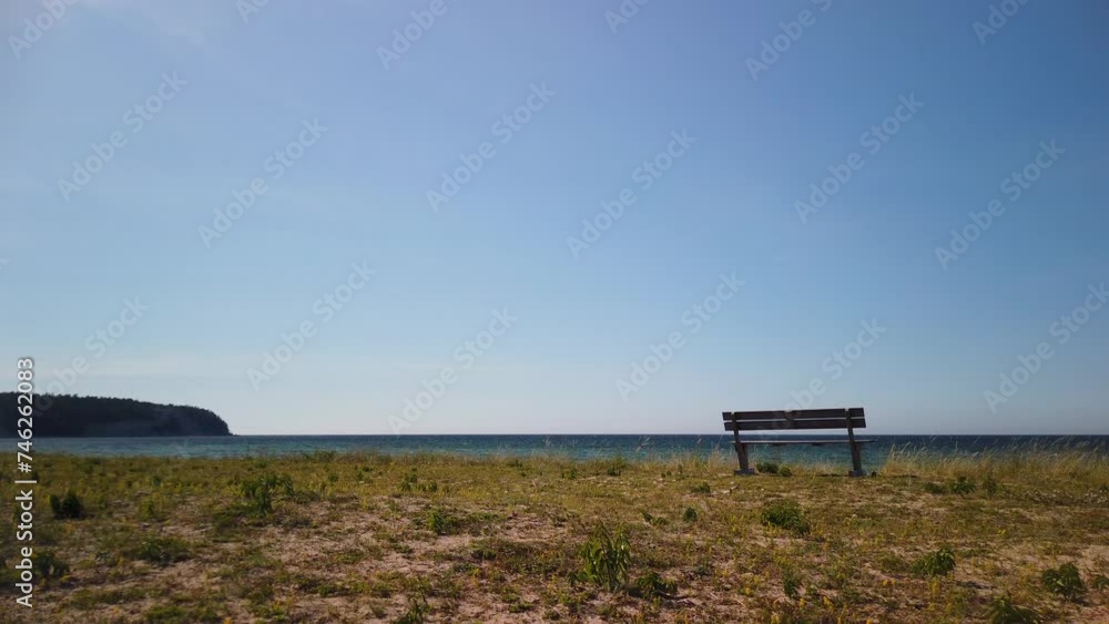 Lone bench overlooking the sea on Gotland's Irevik, clear sky, daytime Lone bench overlooking the sea on Gotland's Irevik, clear sky, daytime