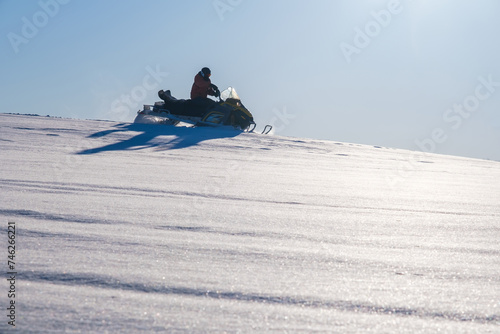 Athlete on a snowmobile moving in the winter forest in the mountains of the Southern Urals