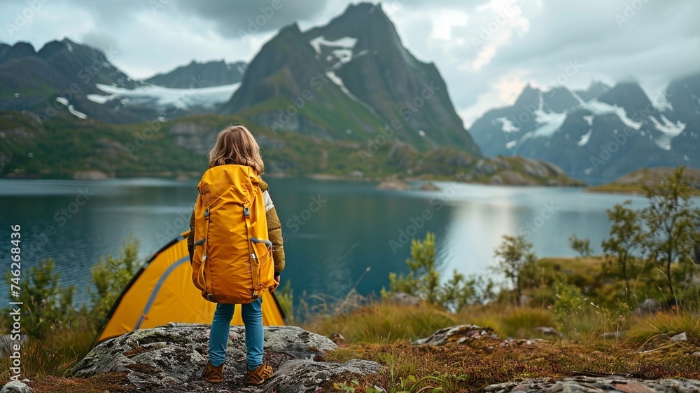 Smiling child on an adventurous family vacation with camping tent gear, hiking, and a healthy outdoor lifestyle while visiting Norway's highlands.