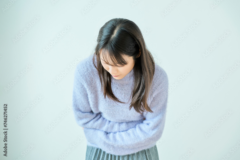 腹痛に苦しんでいる様子の若い女性 腹痛に苦しんでいる様子の若い女性