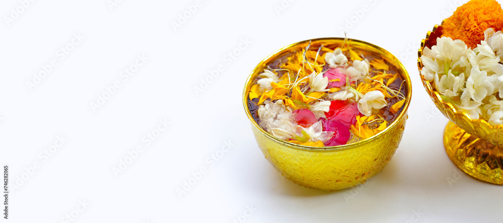 Fototapeta premium Water with jasmine flower, marigold petal and rose petal in golden bowl. Thai tradition, Songkran festival concept
