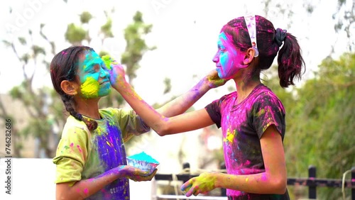 Happy Cute Indian kids applying colours on each other on the occasion of colors festival holi