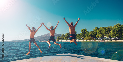 Happy family jumping together into water- beach,sea,vacation,summer holiday, play and fun concept