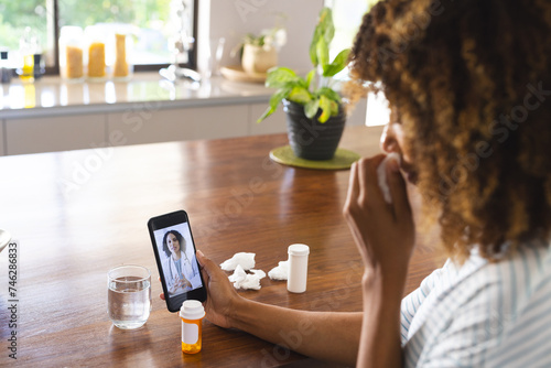 Biracial woman consults a doctor via video call at home