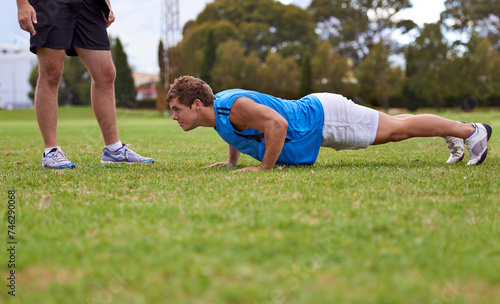 Men, push up and personal trainer on field for exercise with counting for stats, progress or development. Person, coach or mentor with inspection for balance, training or workout for health on grass