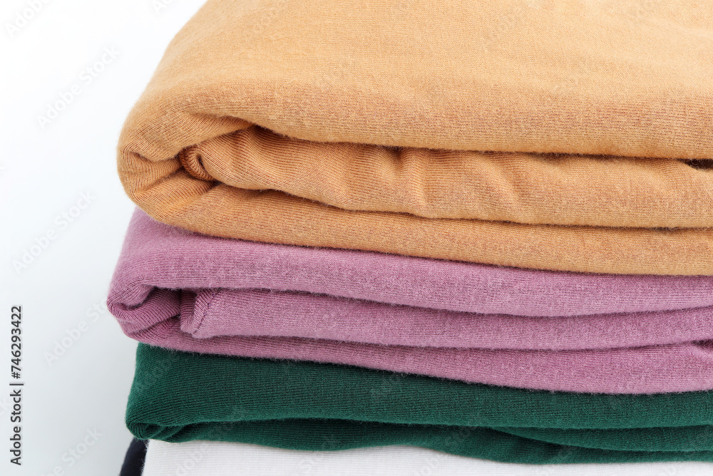 Pile of colorful t-shirts on white background. Pile of colorful t-shirts on white background.