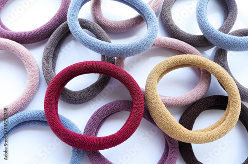Multi-colored hair ties on white background on white background. Top view. Multicolored elastics, comfortable elastic bands for hair