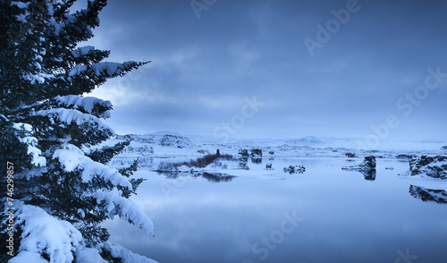 A snowy landscape with a lake and mountains photo