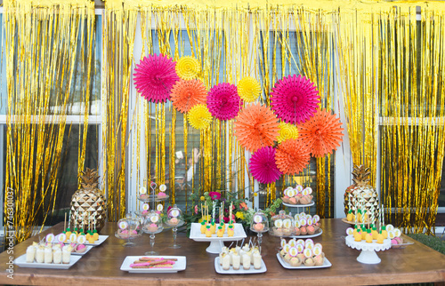 Dessert Table with Pineapple Decorations on a Wooden Table photo