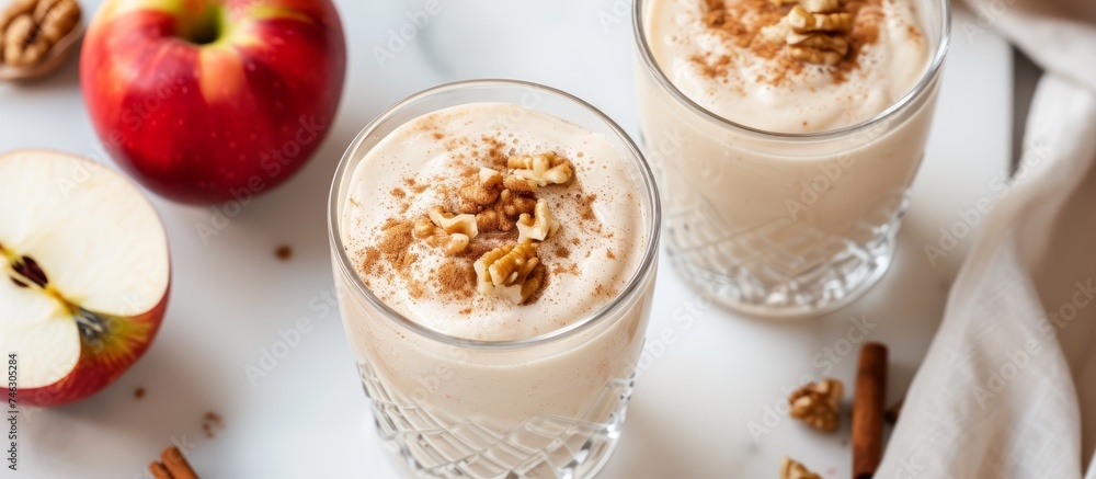Delicious apple pie smoothie served in two glasses with fresh apples and cinnamon Delicious apple pie smoothie served in two glasses with fresh apples and cinnamon