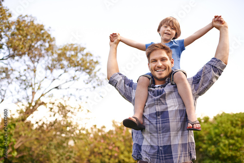 Smile, nature and child on father shoulders in outdoor park or field for playing together. Happy, bonding and portrait of excited young dad carrying boy kid for fun in garden in Canada for summer.