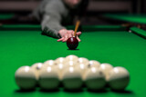 Billiard man player arm breaking the pyramid by striking the ball with cue stick