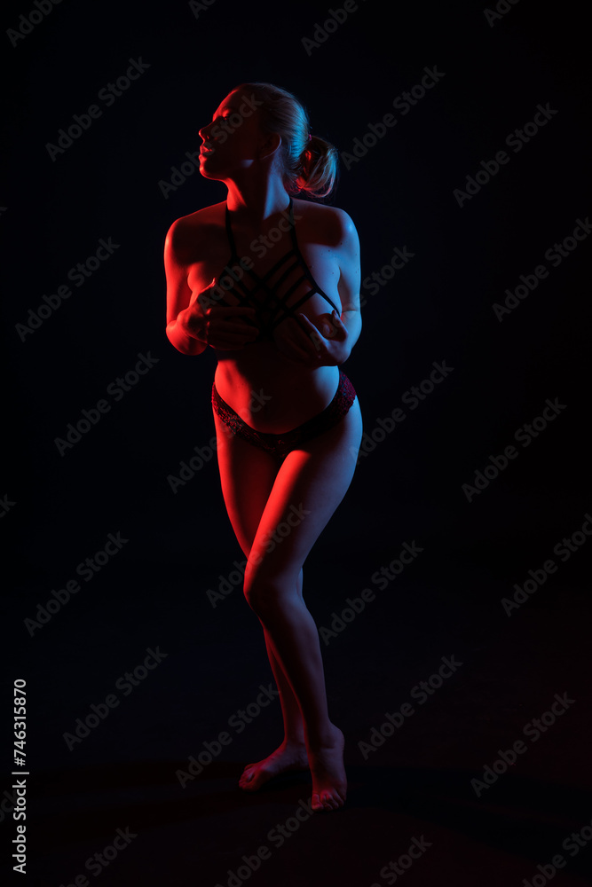 Fototapeta premium Low key portrait of beautiful female body on dark background