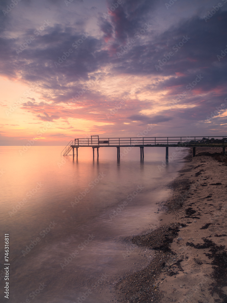 Tranquil Swedish Pier at Sunset With Calm Sea and Colorful Skies