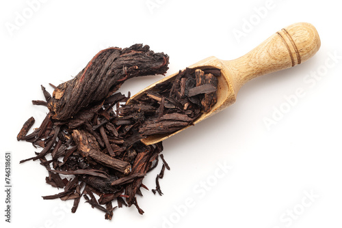 Top view of a wooden scoop filled with Organic Alkanet or Ratan Jot (Alkanna tinctoria) roots. Isolated on a white background. photo