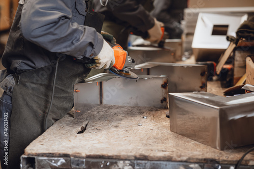men cutting steel with angle grinder