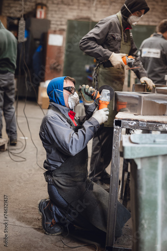 men cutting steel with angle grinder