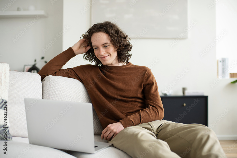 Handsome young man using laptop computer at home. Student men resting in his room. Home work or study, freelance, online learning and casual business concept Handsome young man using laptop computer at home. Student men resting in his room. Home work or study, freelance, online learning and casual business concept