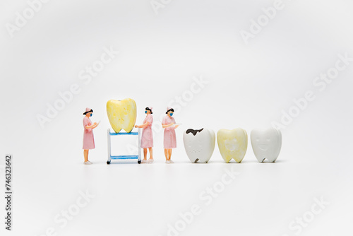 Yellow teeth were forced by nurse to checking dental examination and treatment on white background