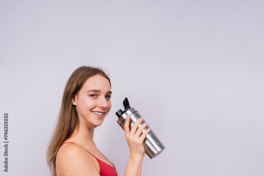 Image of beautiful strong happy cheerful young sports woman posing isolated indoors drinking water. Image of beautiful strong happy cheerful young sports woman posing isolated indoors drinking water.