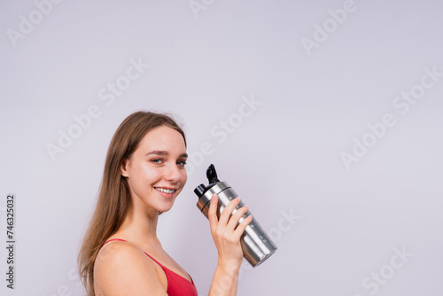 Image of beautiful strong happy cheerful young sports woman posing isolated indoors drinking water.