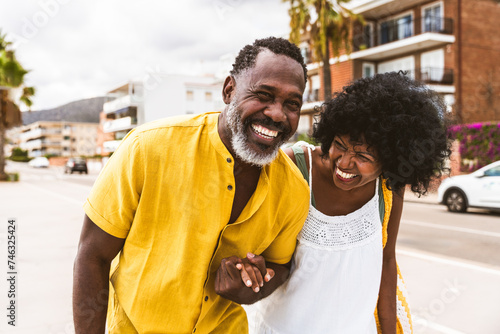 Beautiful mature black couple of lovers dating at the seaside - Married african middle-aged couple bonding and having fun outdoors, concepts about relationship, lifestyle and quality of life photo