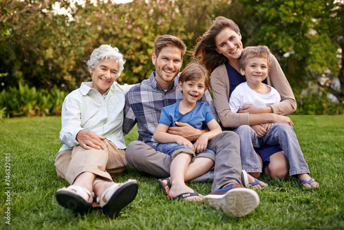 Nature, portrait and children with parents and grandmother relaxing on grass in outdoor park or garden. Smile, family and boy kids on lawn with mom, dad and grandma for bonding in field together.