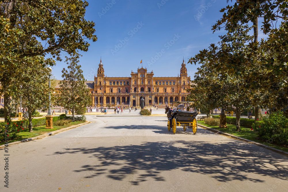 Fototapeta premium Coche de caballos paseando junto a la Plaza de España en el Parque de María Luisa de Sevilla, Andalucía, España